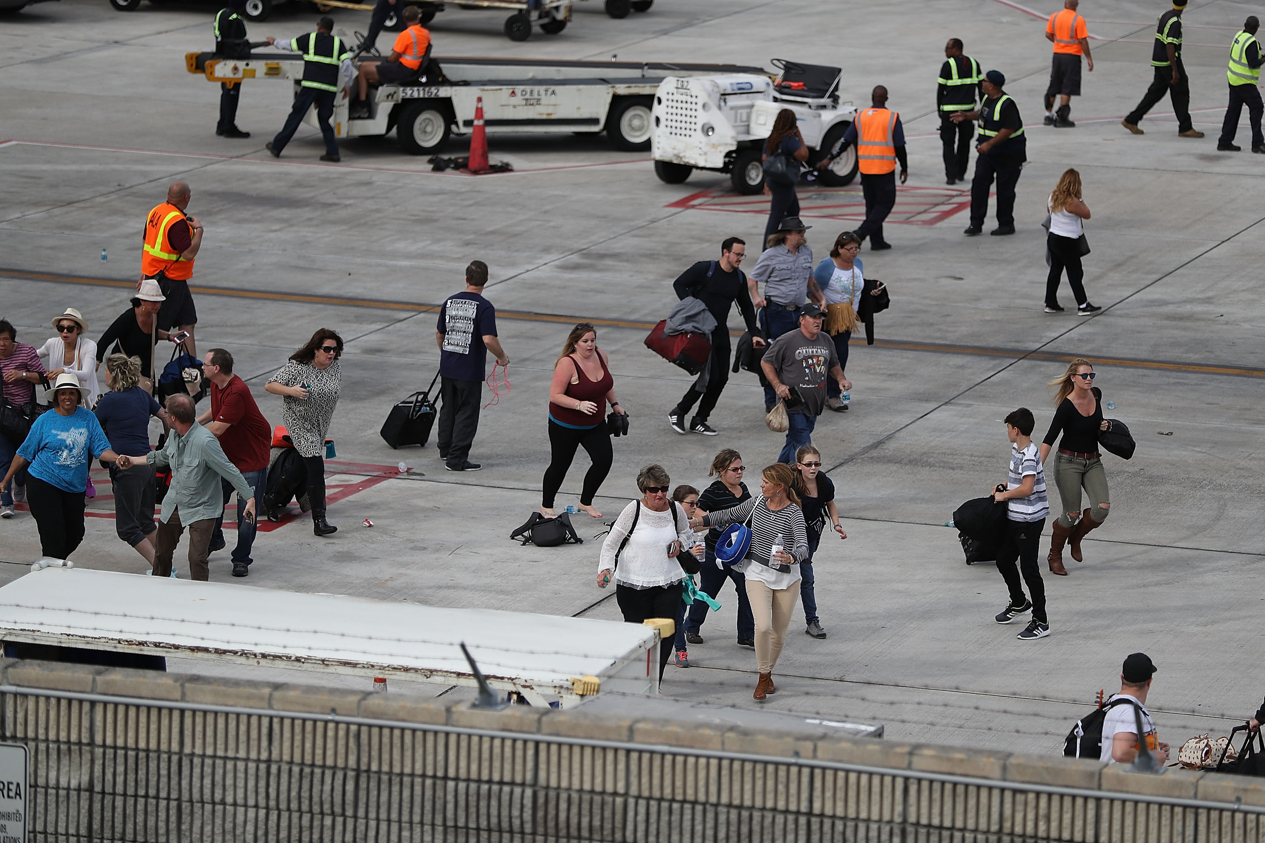 FORT LAUDERDALE, FL - JANUARY 06: People seek cover on the tarmac of Fort Lauderdale-Hollywood International airport after a shooting took place near the baggage claim on January 6, 2017 in Fort Lauderdale, Florida. Officials are reporting that five people were killed and eight wounded in an attack by a single gunman. Joe Raedle/Getty Images/AFP